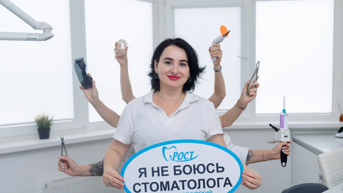 Сотрудница клиники с шуточной табличкой «Я не боюсь стоматолога»